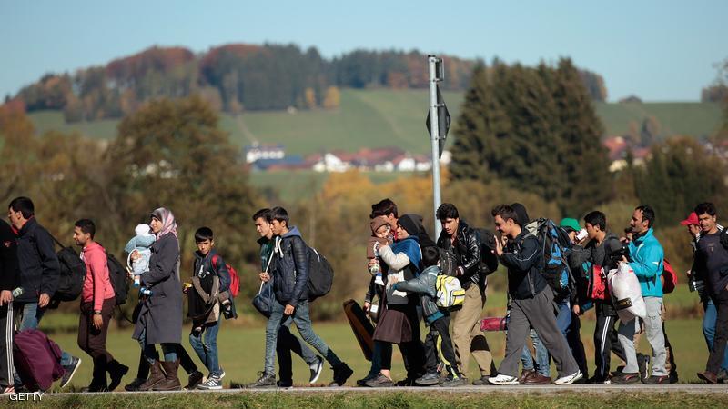 German police lead arriving migrants across a field to a transport facility after gathering them at the border to Austria on October 28, 2015 near Wegscheid, Germany. Bavarian Governor Horst Seehofer has accused the Austrian government of wantonly shuttling migrants in buses from the Slovenian border across Austria and dumping them at all hours of day and night at the border to Germany. German authorities have recorded over 7,000 migrants arriving daily since the weekend as a bottleneck of migrants in Slovenia and Croatia finally arrived in Austria. Germany has registered over 800,000 migrants this year and Chancellor Angela Merkel is mounting pressure on European Union member states that so far have shown great reluctance to accept any migrants at all to finally share the burden of accommodating the newcomers, many of whom are refugees fleeing war-torn Syria.