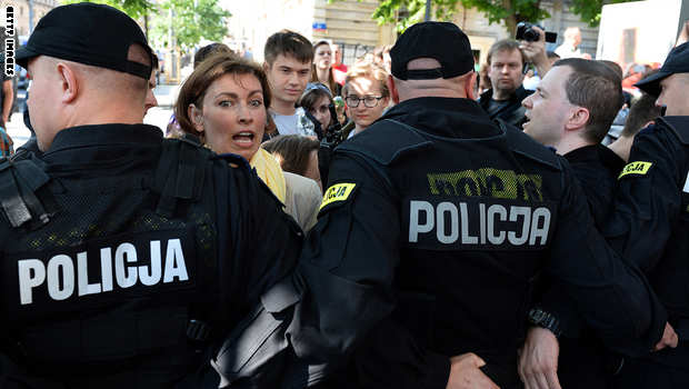 Catholic protesters get stopped by policemen as they demonstrate in front of the entrance to a theater where a play "Golgotha Picnic" by Argentinian author Rodrigo García was staged on June 27, 2014 in Warsaw. The play interweaves critique of consumer society and deconstruction of Jesus of Nazareth and his message. A staging of the play in the western Polish city of Poznan was earlier canceled following similar protests. AFP PHOTO / JANEK SKARZYNSKI (Photo credit should read JANEK SKARZYNSKI/AFP/Getty Images)