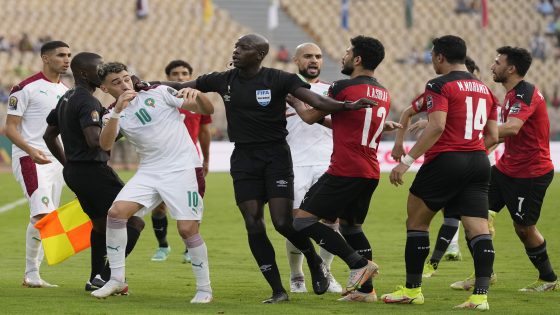 Referee Maguette Ndiaye of Senegal, centre, separates Morocco's Munir El Haddadi, left, and Egypt's Ayman Ashraf, during the African Cup of Nations 2022 quarter-final soccer match between Egypt and Morocco at the Ahmadou Ahidjo stadium in Yaounde, Cameroon, Sunday, Jan. 30, 2022. (AP Photo/Themba Hadebe)